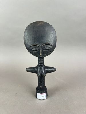 une figurine d'extraterrestre devant laquelle se trouve une bouteille de vin