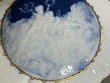 a white plate with a blue sky and clouds on it