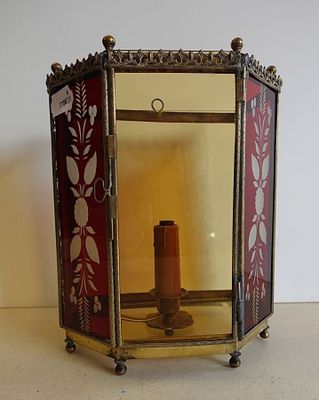 une lanterne rouge et dorée avec une bougie à l'intérieur