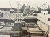 a black and white photo of a boat docked at a dock
