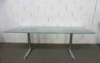 une table en verre avec des pieds en métal et un plateau en verre