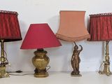 four lamps are lined up on a white table with a red shade