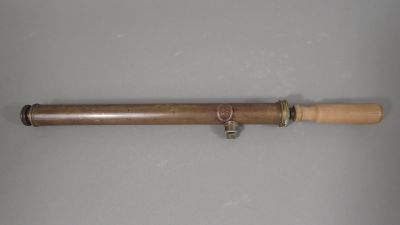 an old telescope with a wooden handle on a white surface
