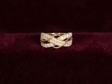 un gros plan d'une bague en or sertie de diamants posée sur une surface en velours