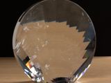une boule de cristal posée sur une table, sur fond noir