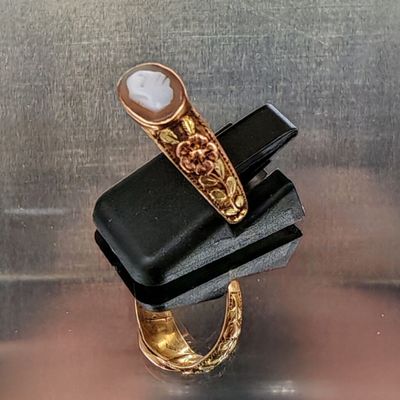 une bague en or sertie d'une pierre blanche, montée sur un bijou noir