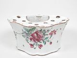 un petit vase blanc orné d'un motif de roses