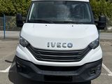 la camionnette blanche est garée sur un parking avec des arbres en arrière-plan