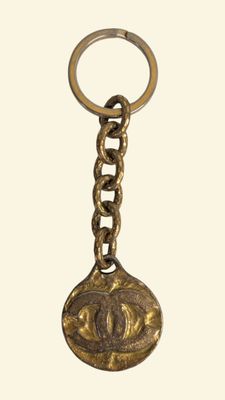 un porte-clés entouré d'une chaîne à laquelle est accrochée une pièce de monnaie