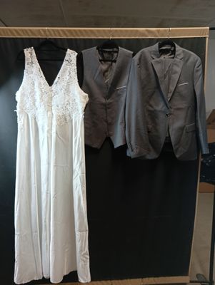 deux costumes et une robe exposés dans une pièce