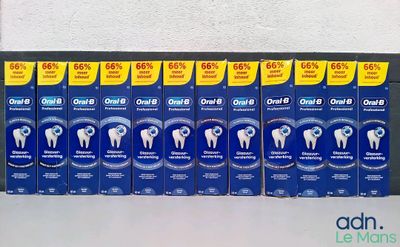 Plusieurs boîtes de dentifrice sont alignées sur une étagère