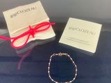 un gros plan d'un bracelet posé sur une table, à côté d'une boîte