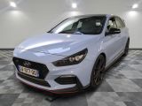 une voiture blanche garée dans un garage au sol en damier