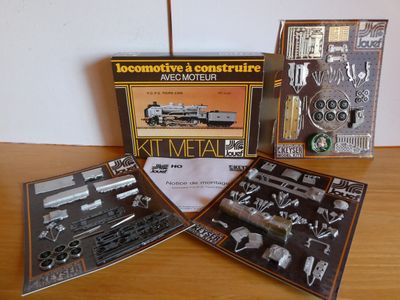 trois types différents de trains miniatures posés sur une table