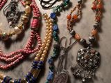 Plusieurs colliers et bracelets sont disposés sur une surface en marbre