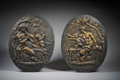 pair of bronze plaques depicting a man and a woman in a garden