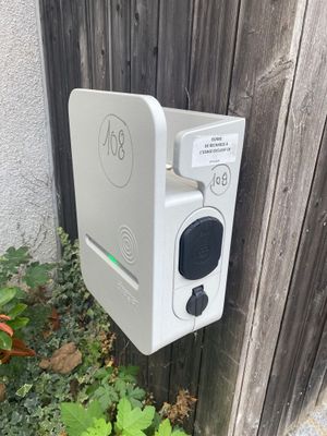 un appareil électronique blanc fixé sur le côté d'une clôture en bois