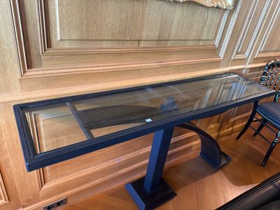 une table en verre avec un piètement noir et un piètement bleu