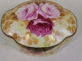 a decorative box with pink roses on it on a table