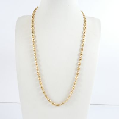 un collier à chaîne en or orné de perles, porté par un mannequin