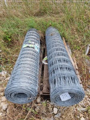 deux rouleaux de fil barbelé posés sur une caisse en bois