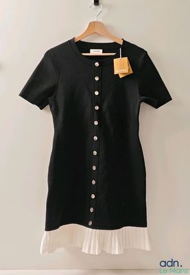 a black and white dress hanging on a wall next to a hanger