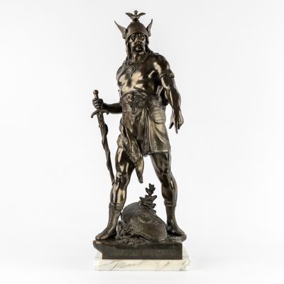 une statue en bronze représentant un homme tenant une épée et un bouclier