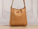un sac à main en cuir beige posé sur une table en bois