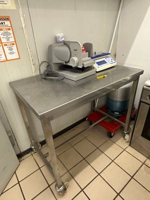 une cuisine équipée d'une table en inox et d'une cuisinière