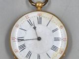 a gold pocket watch with roman numerals on the face