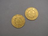 two pieces of gold coins sitting on top of a table