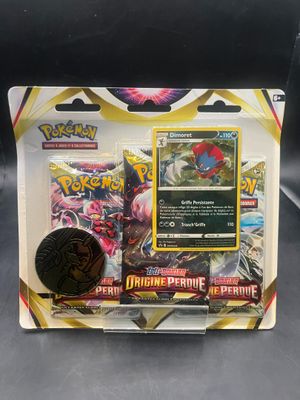 un gros plan sur une boîte de cartes Pokémon avec une pièce de monnaie