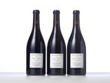 three bottles of wine are lined up on a table