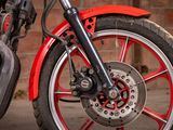 a red motorcycle parked next to a brick wall
