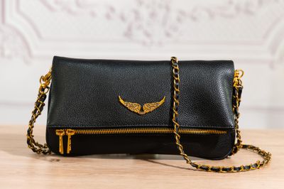 pochette en cuir noir avec une bandoulière en chaîne dorée
