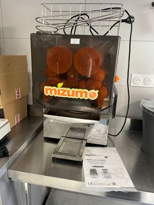 a machine that has oranges in it in a kitchen