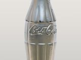 a silver coke bottle with a red cap on it