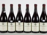 six bottles of wine are lined up in a row on a table