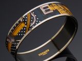 two bangles with designs on them sitting next to each other