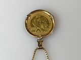 necklace with a coin on a chain on a white surface