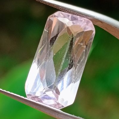 un diamant rose maintenu par une paire de pinces