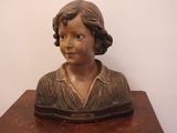 a statue of a woman sitting on top of a wooden table