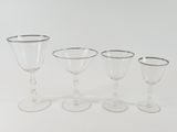three wine glasses and a wine glass are sitting on a white surface