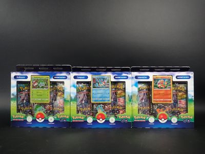 Quatre cartes à collectionner Pokémon sont alignées les unes à côté des autres sur une surface noire.