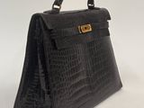 a black crocodile skin handbag with gold hardware