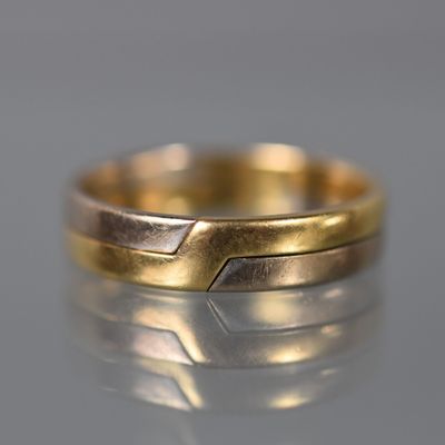 gros plan d'une bague en or sur une surface réfléchissante