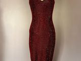 robe rouge à paillettes sur un mannequin devant un mur
