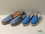 three pairs of blue and white slippers sitting on top of a table
