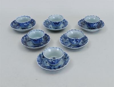 six tasses à thé et soucoupes bleues et blanches posées sur une surface blanche