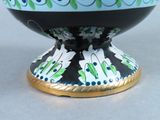 a black and white bowl with blue and green designs on it